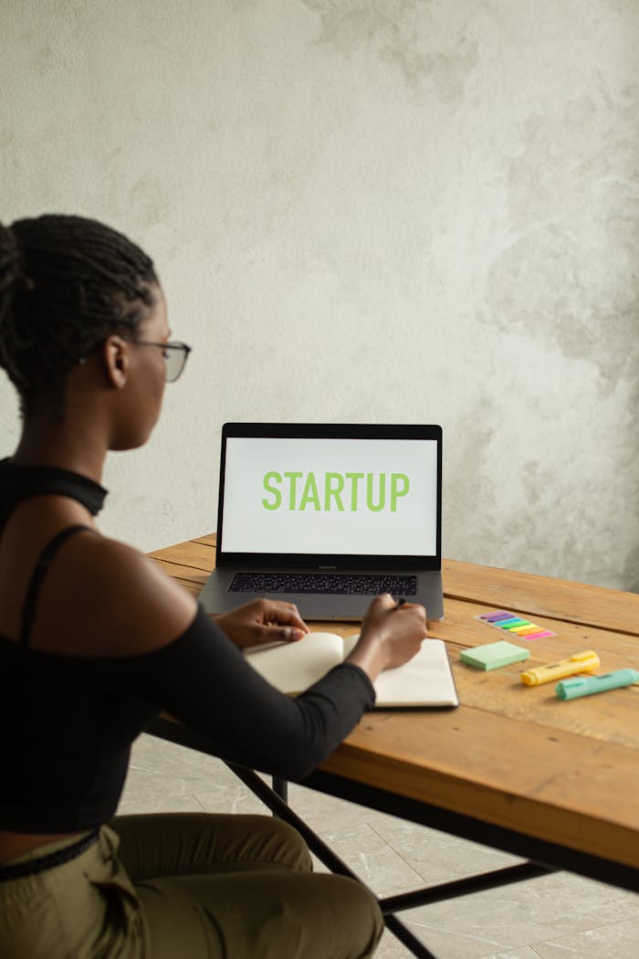 African American woman working on a startup project at home, using a laptop.